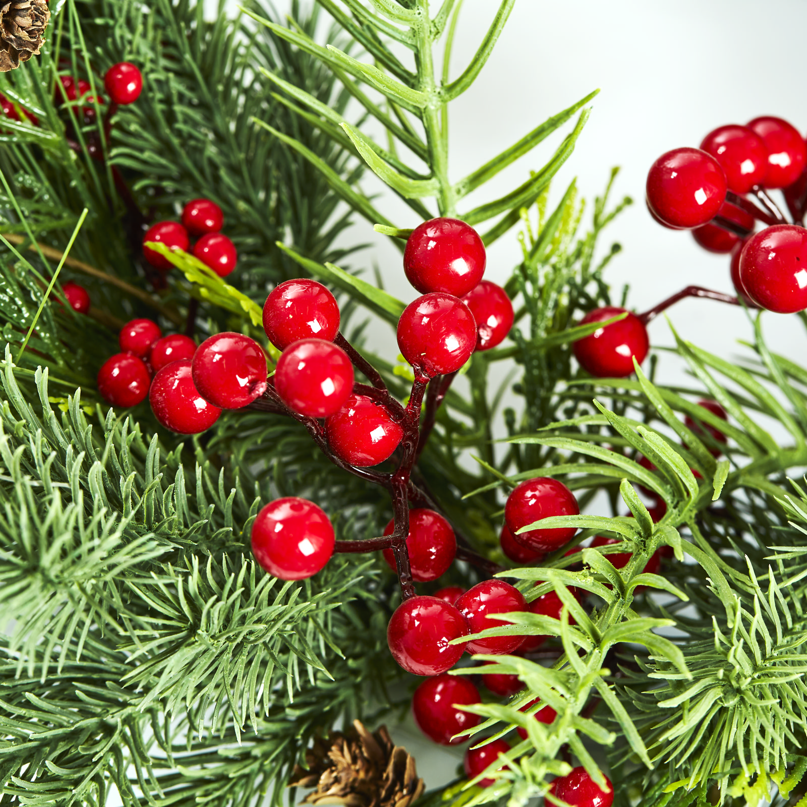 Røde bær og grangrene på kunstig julekrans – detalje
