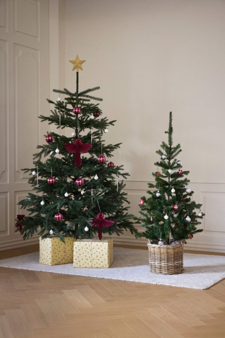 Stort og lille kunstigt juletræ pyntet i stuen